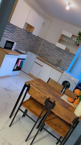 - une table et des chaises en bois dans la cuisine dans l'établissement OT Appart City Logement élégant et central, à Clermont-Ferrand