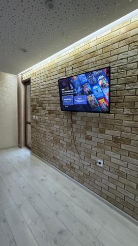VratsaにあるSunny & Stylish Apartmentの煉瓦壁のテレビ付き壁