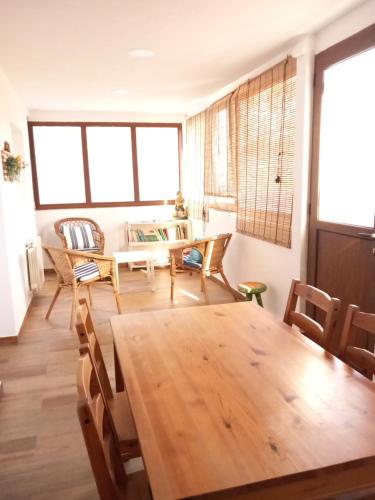 a dining room with a wooden table and chairs at Apartamento con jardín a 5 minutos de la playa in Colunga