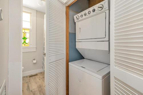 a white kitchen with a washer and dryer at Sunshine Daydreams - 4310 Seventh Street in Saint Simons Island