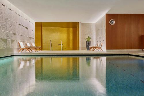 a swimming pool with two chairs and a table at Bvlgari Hotel London in London