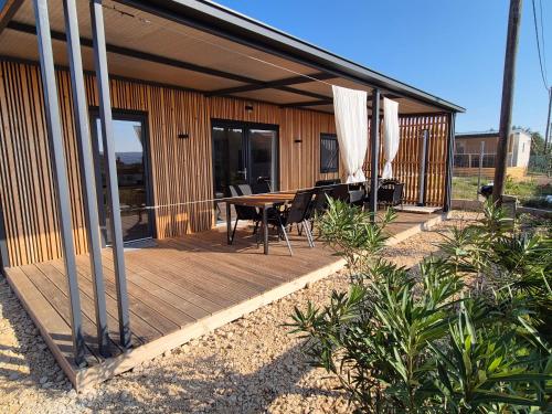 a wooden deck with a table and chairs on it at Hiška Morska ravnica in Sveti Petar