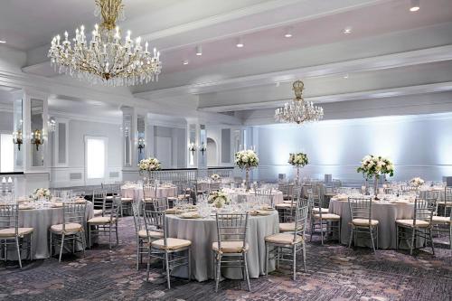 a banquet hall with tables and chairs and chandeliers at The Mayflower Hotel, Autograph Collection in Washington