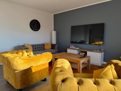 a living room with two yellow couches and a table at AhA in Lingen