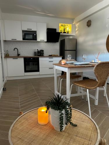 une cuisine avec une table et des chaises ainsi qu'une salle à manger dans l'établissement Le Namasté, à La Ciotat