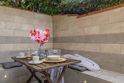a table with a vase of flowers on it at Dolce Vita Spa & Terrace Suite by C&G in Florence