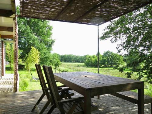 une table en bois et deux chaises sur une terrasse dans l'établissement Lodge Ultranature, Envrionnement naturel - 25 mn du Puy - Terrasse avec Vue Imprenable - Idéal Déconnexion, à Saint-Mesmin