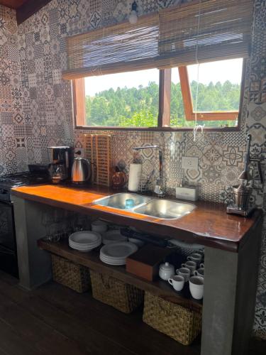 a kitchen counter with a sink and a window at Medio Cielo Cabaña de Montaña in Rincón de Luna