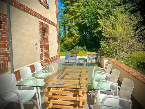 d'une terrasse avec une table et des chaises en verre. dans l'établissement Domaine du Bal, à Touques