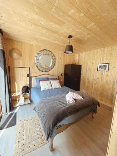 une chambre avec un lit dans une pièce aux murs en bois dans l'établissement Domaine du Bal, à Touques