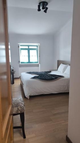 a bedroom with a bed and a window at Casa da Praça in Torre de Moncorvo