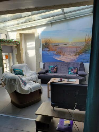 un salon avec un canapé et une table dans l'établissement GITE LES MOUETTES MAISON A 300m de la MER, à Pirou