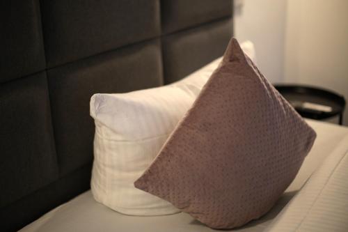 two pillows sitting on top of a bed at Amical Hotel Hagen - Am Hauptbahnhof in Hagen