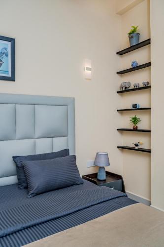 a bedroom with a bed with a blue comforter at Mzion Hotel Weligama in Weligama