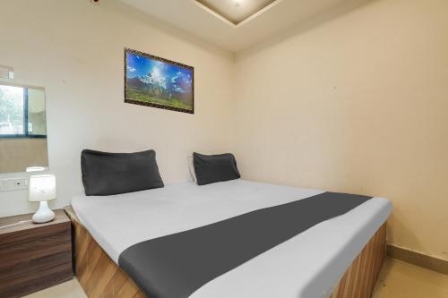 a bedroom with a large bed in a room at Hotel O Gyan Regency in Raipur