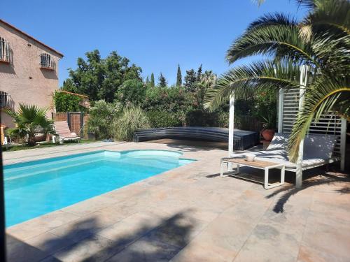 un homme posé sur une chaise à côté d'une piscine dans l'établissement Domaine des Pins, à Saint-Estève