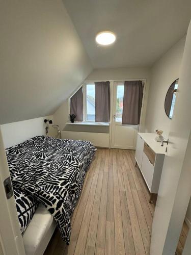 a bedroom with a zebra print bed and a window at Charming house for 11 persons in Odense with Luxury Rooftop Deck & Free Parking in Odense