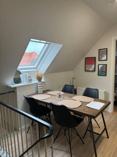 a table and chairs in a room with a window at Charming house for 11 persons in Odense with Luxury Rooftop Deck & Free Parking in Odense