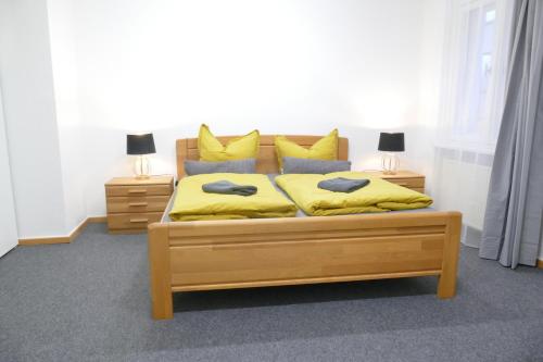 a bedroom with a bed with yellow sheets and pillows at Innenstadt - 110m2 wunderschöner Altbau am Landesmuseum mit 3 Schlafzimmern und 2 Bädern in Greifswald