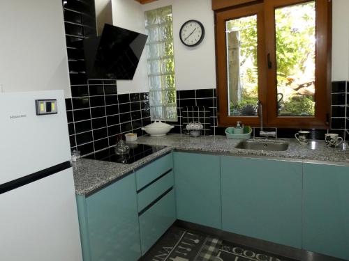 una cocina con armarios azules y un reloj en la pared en Casa Daniel, en Riberas del Sor