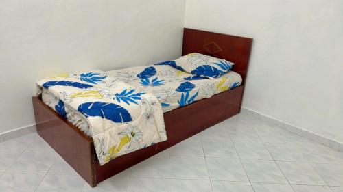 a bedroom with a bed with blue flowers on it at Homestay Semenyih Hakim in Semenyih