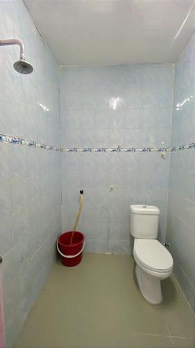 a bathroom with a toilet and a red bucket at Homestay Semenyih Hakim in Semenyih