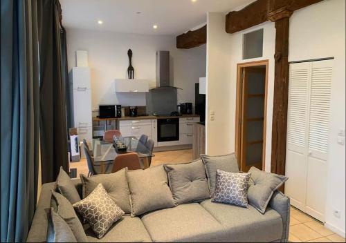 a living room with a couch and a kitchen at Appartement lumineux et cosy avec jardin vue sur chateau près Port en Bessin, Bayeux et Omaha Beach in Commes