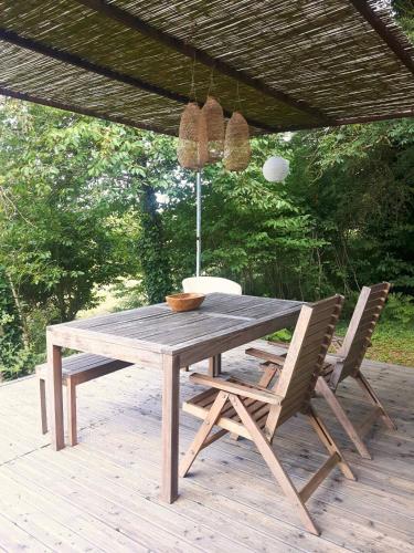 une table et des chaises en bois sur une terrasse dans l'établissement Lodge Ultranature, Envrionnement naturel - 25 mn du Puy - Terrasse avec Vue Imprenable - Idéal Déconnexion, à Saint-Mesmin