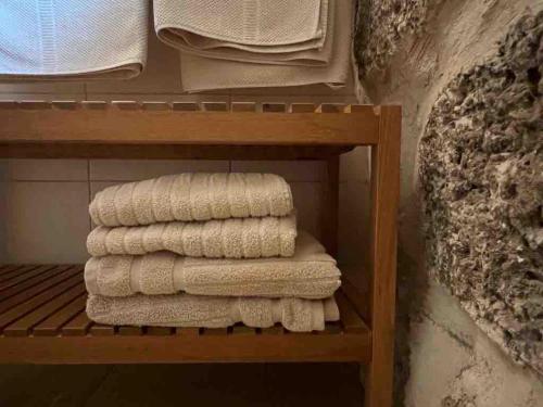 - un ensemble de serviettes sur une étagère dans une salle de bains dans l'établissement Mediterranean Stone Cottage, à Zikhron Yaakov