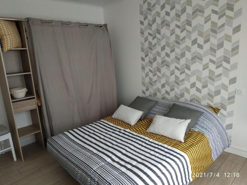 un letto con due cuscini sopra in una camera da letto di Appartement 2km de la mer, La résidence de Thora a Billiers