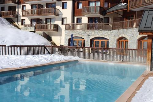 - une piscine avec de la neige au sol à côté d'un bâtiment dans l'établissement Superbe T2 classé 3 étoiles bien situé, à Villarembert