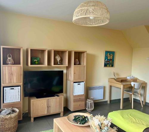 Una sala de estar con un televisor grande y una mesa. en L'Opaline, Ravissante maison familiale, Wimereux, en Wimereux