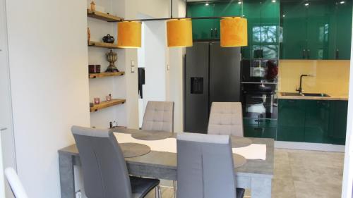 a kitchen with a dining room table and chairs at AP Apartment's Zielony in Szczawno-Zdrój