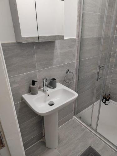 a bathroom with a sink and a shower at Luxury 1-Bedroom Apartment - Central Dundee in Dundee