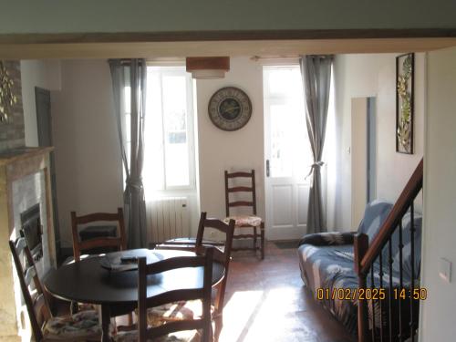 a living room with a table and a couch at maison des trois rivières in Trévières