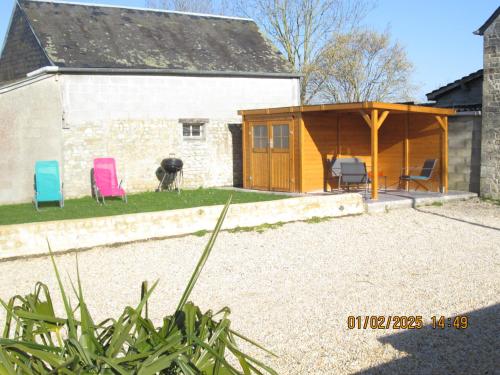 a house with a pavilion and chairs in a yard at maison des trois rivières in Trévières