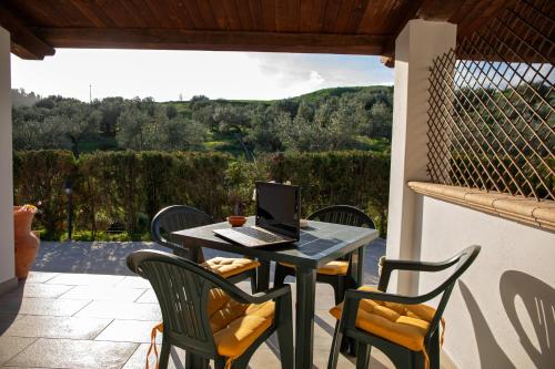 a table with a laptop on it on a patio at Tenuta Severino in Santa Caterina Dello Ionio Marina