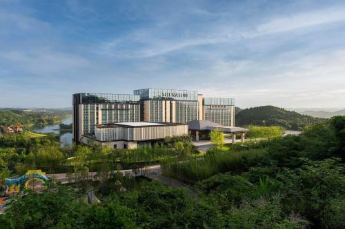 a large office building with a river in front of it at Sheraton Mianyang in Mianyang