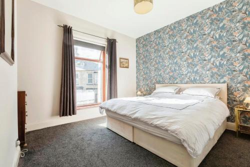 a bedroom with a large bed with a floral wallpaper at The Prince's Eyrie - Spacious, comfy and cosy in Bishop Auckland