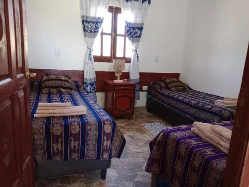 a room with two beds and a window at Casa DE CAMPO SUMAQ WASI in Cachí