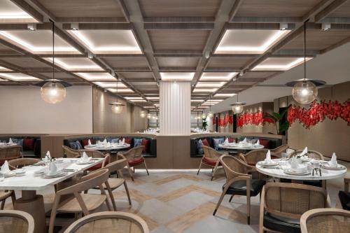 a dining room with tables and chairs and lights at Sheraton Mianyang in Mianyang