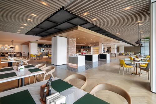 a restaurant with tables and chairs in a cafeteria at Sheraton Mianyang in Mianyang