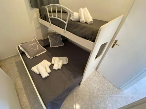 a small bedroom with a bunk bed with towels on the floor at Petra Marina Aurora in Pisciotta