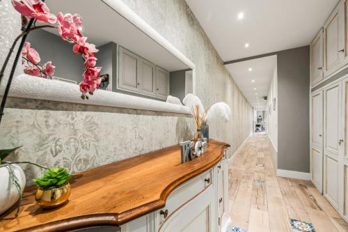 a kitchen with white cabinets and a wooden counter top at Dolce Vita Spa & Terrace Suite by C&G in Florence