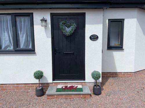 Eine schwarze Tür mit einem Herzkranz drauf. in der Unterkunft Blackberry Cottage in Cardiff