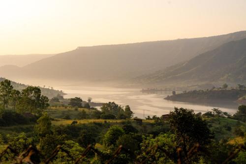 a misty view of a river in a valley at Mysticstays Resort in Wai