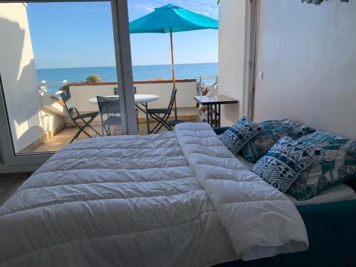 Ce lit se trouve dans une chambre avec vue sur l'océan. dans l'établissement Studio Tahiti beach face à la mer, à Frontignan