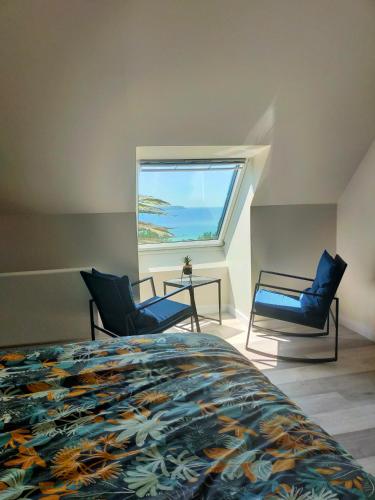 une chambre avec un lit et deux chaises et une fenêtre dans l'établissement Trouz ar mor, à Plonévez-Porzay