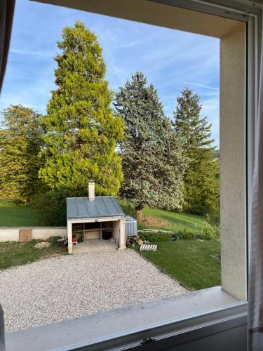 a window view of a picnic table in a yard at Découvrez le calme et la sérénité de la campagne à 45 minutes de Paris in Vert