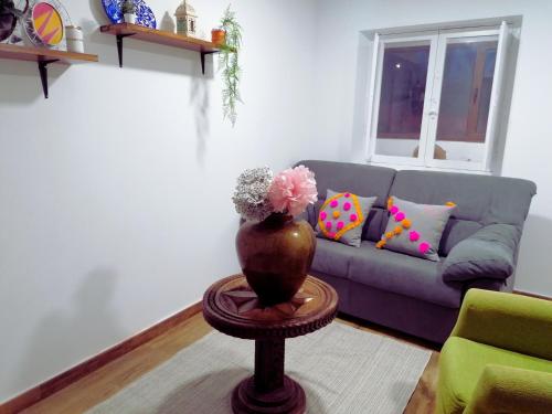 a living room with a couch and a vase on a table at Apartamento con jardín a 5 minutos de la playa in Colunga